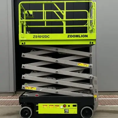 Alt= Een schaarhoogwerker staat voor een gebouw en heeft een hoogte van 12 meter